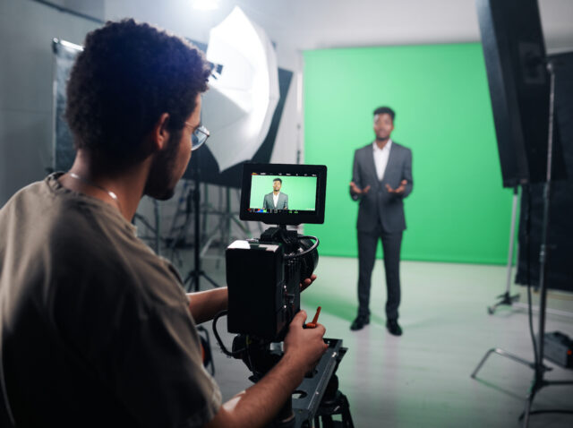 Cameraman using camera to shoot TV program