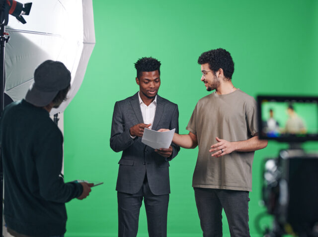 Presenter discussing script with director